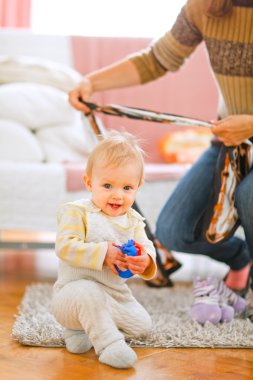 Lovely baby playing on floor clipart