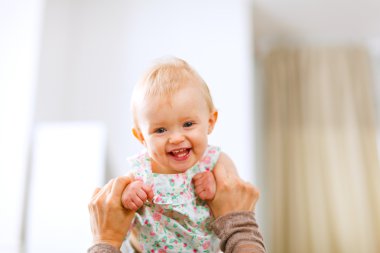 Portrait of lovely laughing baby playing with mother clipart