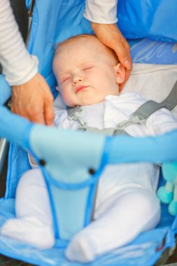 Mother's hand stroking head sleeping in stroller baby clipart