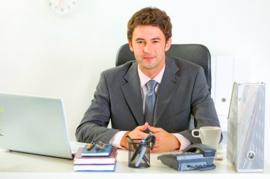 Portrait of happy modern businessman in office clipart