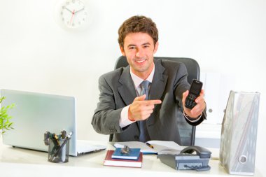 Smiling modern manager pointing on mobile. Contact me gesture clipart