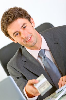 Portrait of modern businessman sitting at office desk clipart