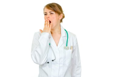 Yawning medical doctor woman holding hand near mouth clipart