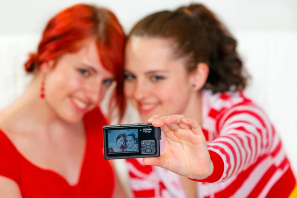 웃고 있는 젊은 여자 친구 두 명 이 소파에 앉아 사진을 찍고 있다 — 스톡 사진