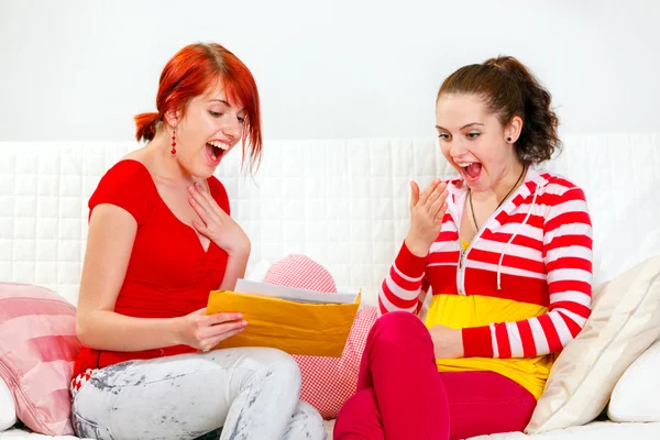 Excited girlfriends reading letter with good news — Stock Photo, Image