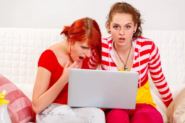Twee vriendinnen verbaasd de gezien in een laptop — Stockfoto