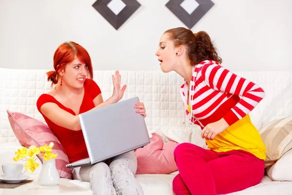 Pretty girl not allowing her girlfriend to look in laptop — Stock Photo, Image
