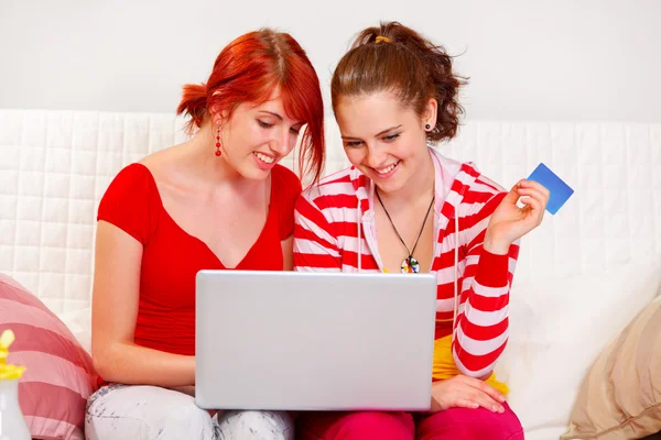 Zwei glückliche Freundinnen, die mit Kreditkarte kaufen — Stockfoto