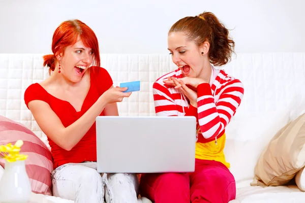 Duas namoradas sorrindo fazendo compra usando cartão de crédito — Fotografia de Stock
