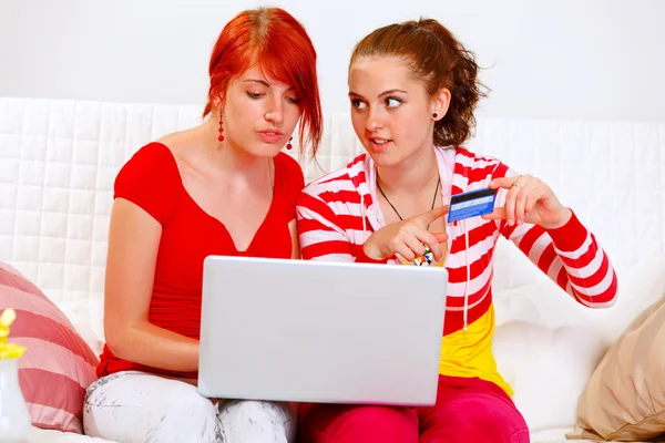 Two pretty girlfriends shopping in net using credit card — Stock Photo, Image