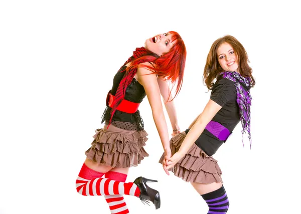 Two pretty cheerful girls standing back to back and holding hands — Stock Photo, Image
