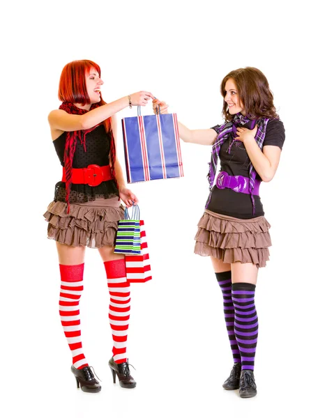 Chica bastante joven con bolsas de compras presentando uno a su novia — Foto de Stock