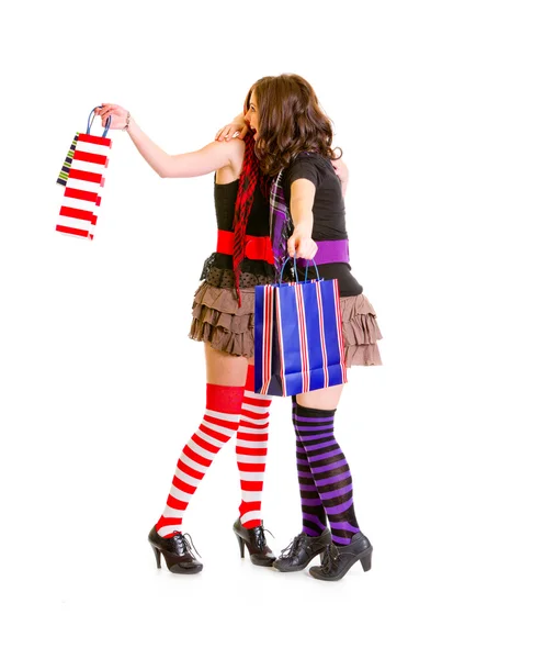Две юные девушки с пакетами для покупок счастливо обнимаются — стоковое фото