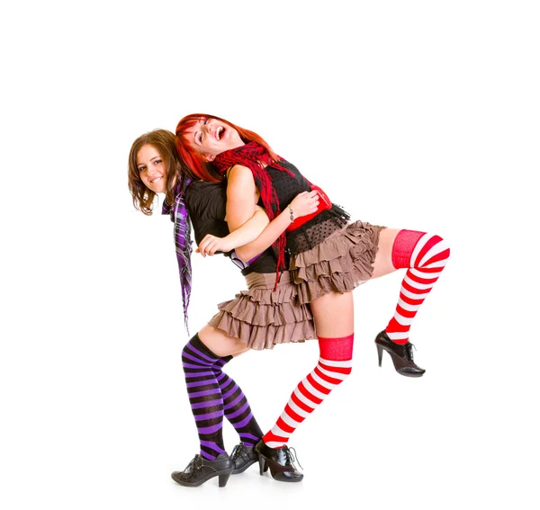 Zwei fröhliche Freundinnen, die Rücken an Rücken stehen und lustig zusammen posieren — Stockfoto
