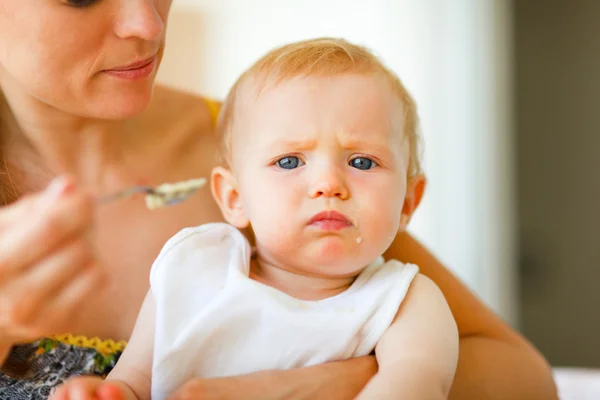 Portrait of eat smeared cute little baby feeding by mama — Stock Photo, Image