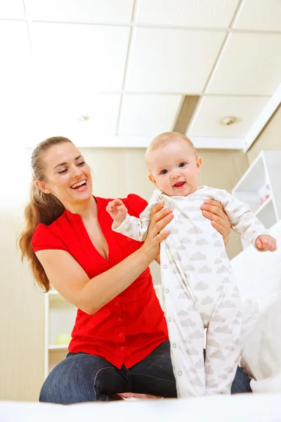 歩くことを学ぶの赤ちゃんを助ける母親を笑顔 — ストック写真