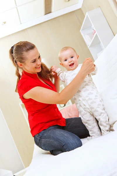 Happy mother helping baby learn to walk — Stock Photo, Image