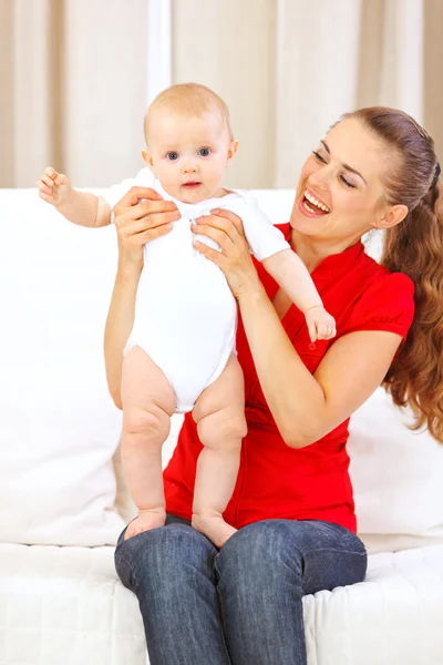 Gelukkig moeders helpen kleine baby permanent op haar ronden — Stockfoto