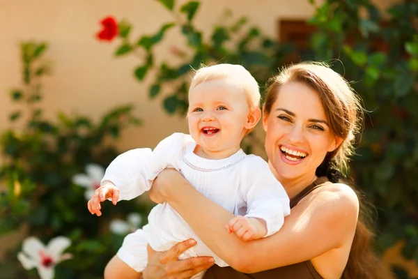 Portrait of smiling mother with baby on street — Stock Photo, Image