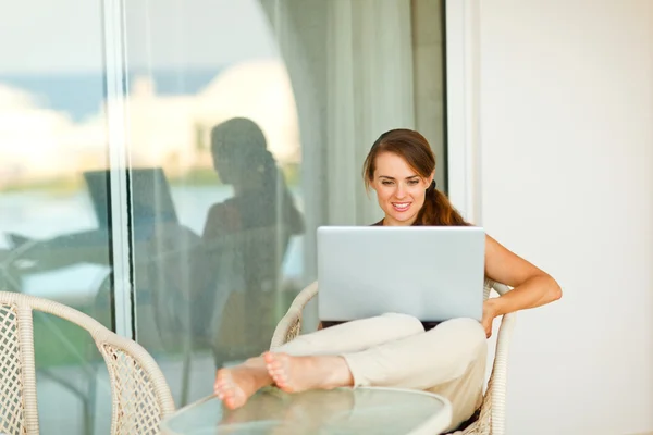 Porträt einer schönen Frau, die auf der Terrasse am Laptop arbeitet — Stockfoto