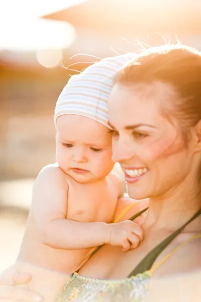 Porträt einer jungen Mutter mit Baby am Strand — Stockfoto