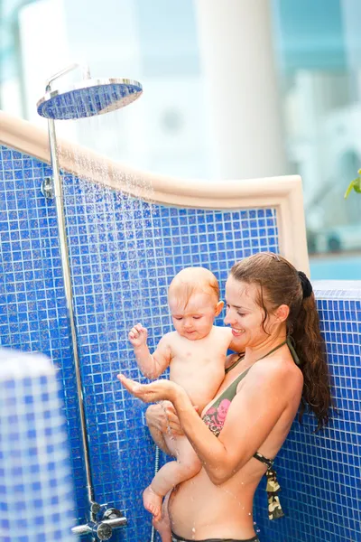 어린 어머니가 아기에게 샤워를 하는 모습 — 스톡 사진