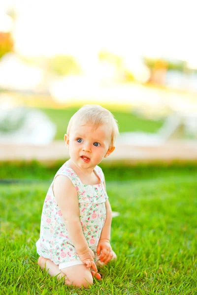 Düşünceli bebek çimenlerin üzerinde oynama — Stok fotoğraf