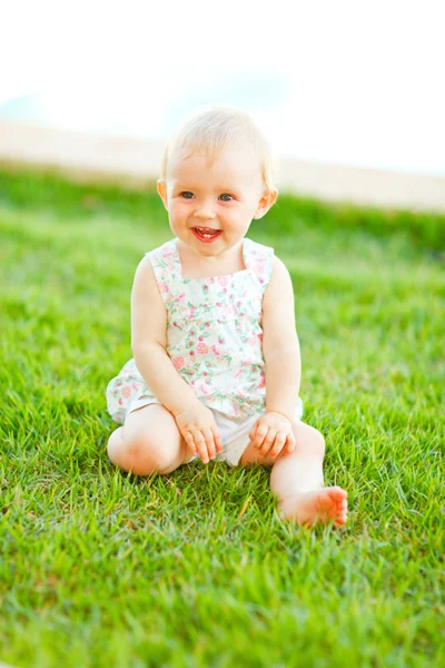 Happy baby sitter på gräset — Stockfoto