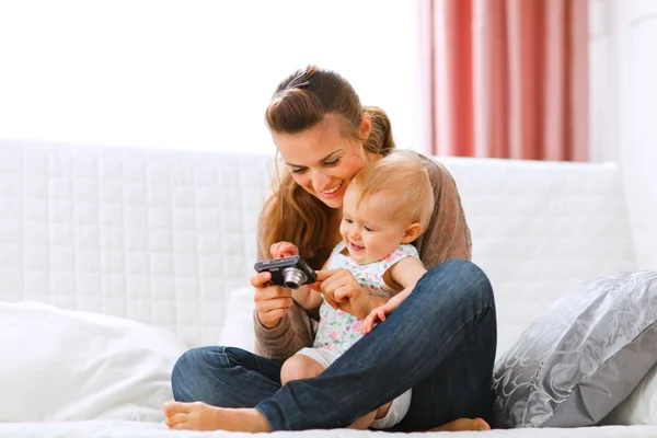 Giovane madre e sorridente bambino guardando foto in macchina fotografica — Foto Stock