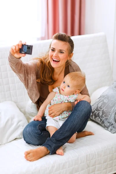 Hermosa joven mamá haciendo fotos con su precioso bebé —  Fotos de Stock