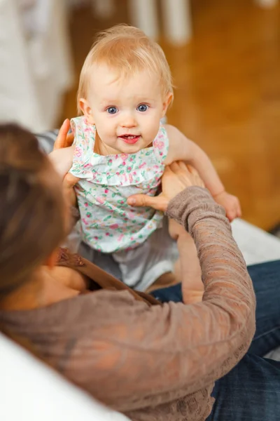 Portrait of cheerful baby playing on mamas knees — Stock Photo, Image