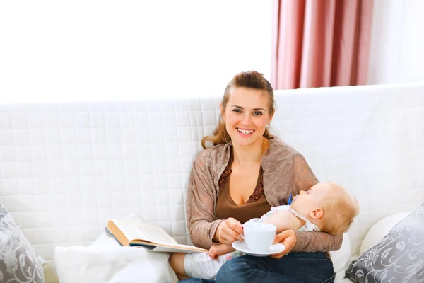 Young mom resting while baby sleep by having coffee and reading — Stock Photo, Image