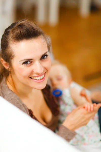 Young beautiful mother with sleeping baby on hands — Stock Photo, Image