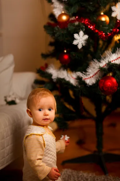 Портрет восхитительного младенца возле елки — стоковое фото