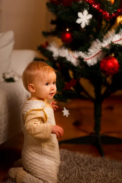 Υπέροχο μωρό κοντά χριστουγεννιάτικο δέντρο που ψάχνουν στην πλευρά — Φωτογραφία Αρχείου