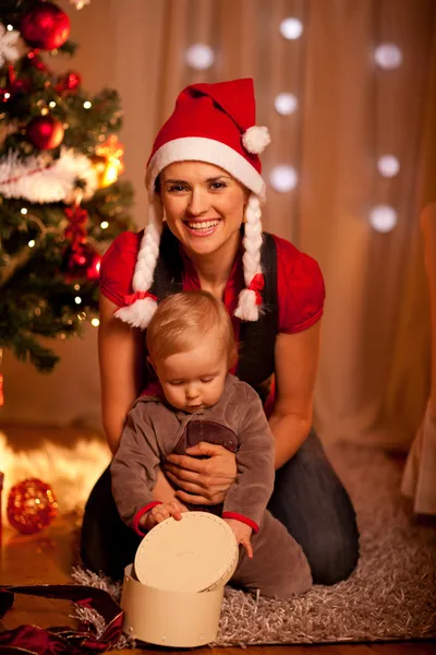 Förtjusande baby nära julgran öppna julklappar med m — Stockfoto