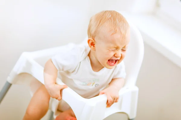Плачущий ребенок в детском кресле — стоковое фото
