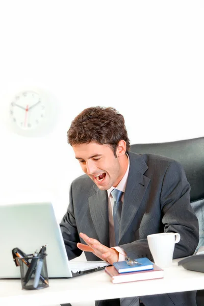 Šokovaný podnikatel, sedí v kanceláři a nespokojeně řvát na la — Stock fotografie