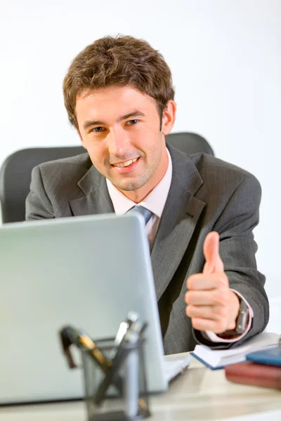 Dizüstü bilgisayarda çalışan ve gösterilen modern işadamı thumbs-up — Stok fotoğraf
