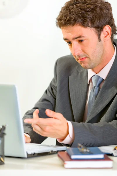 Confuso uomo d'affari moderno seduto alla scrivania di lavoro su la — Foto Stock