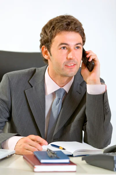 Glücklicher moderner Geschäftsmann sitzt im Büro und spricht mobil — Stockfoto