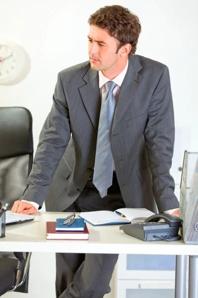 Säker moderna affärsman håller står nära skrivbord en — Stockfoto