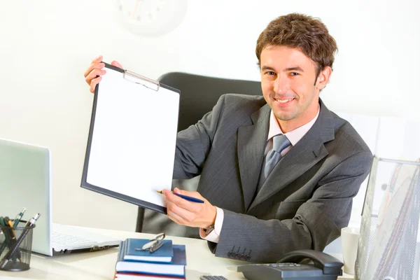 Uomo d'affari sorridente che dà appunti e penna per la firma — Foto Stock