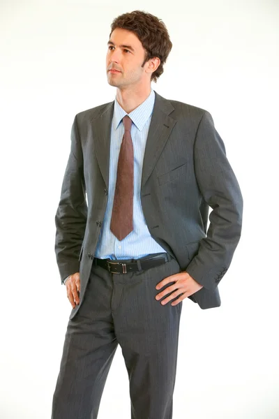 Confident modern businessman with hands on hips looking in corner — Stock Photo, Image