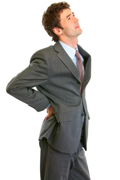 Młody biznesmen trzymając rękę na jego bóle kręgosłupa — Zdjęcie stockowe