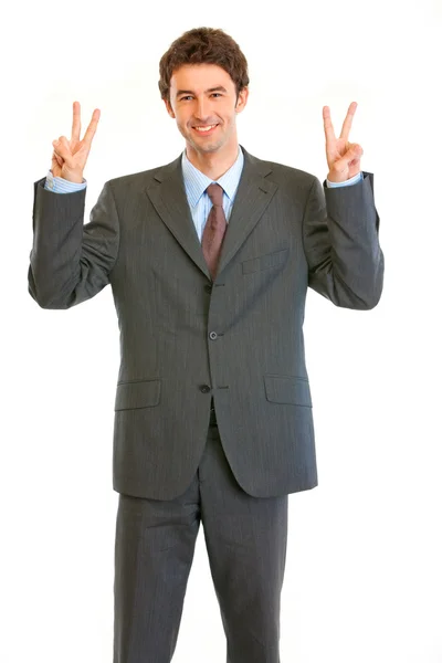 Jovem empresário agradado mostrando gesto de vitória — Fotografia de Stock