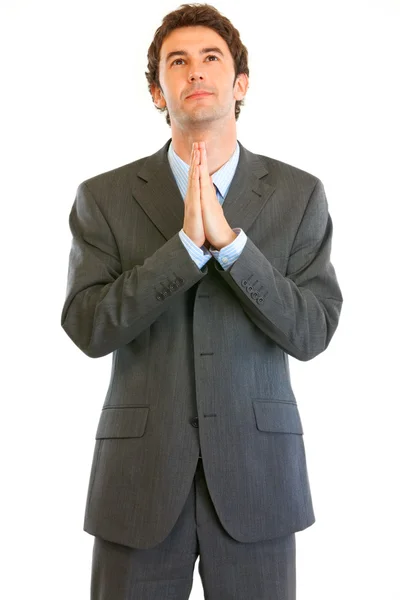 Young businessman with closed eyes praying for success — Stock Photo, Image