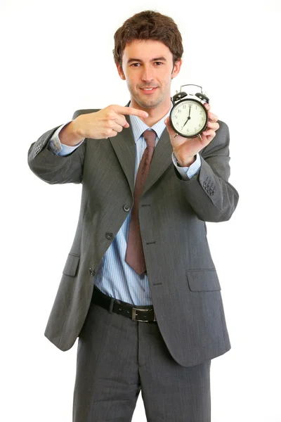 Современный бизнесмен указывает на будильник — стоковое фото