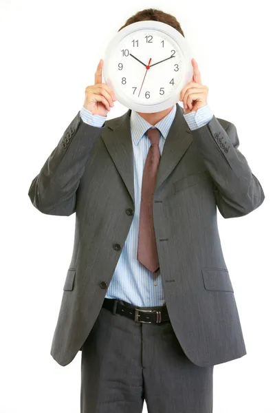 Homem de negócios moderno segurando relógio na frente da cara — Fotografia de Stock