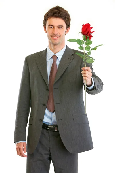 Sonriente hombre de negocios moderno con rosa roja en la mano — Foto de Stock